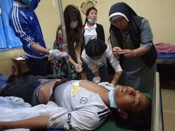 누 따웅 수녀가 가톨릭 교회가 연 치료 센터에서 부상 당한 시민을 치료하며 산모의 출산을 돕고 있다. [누 따웅 수녀 제공]