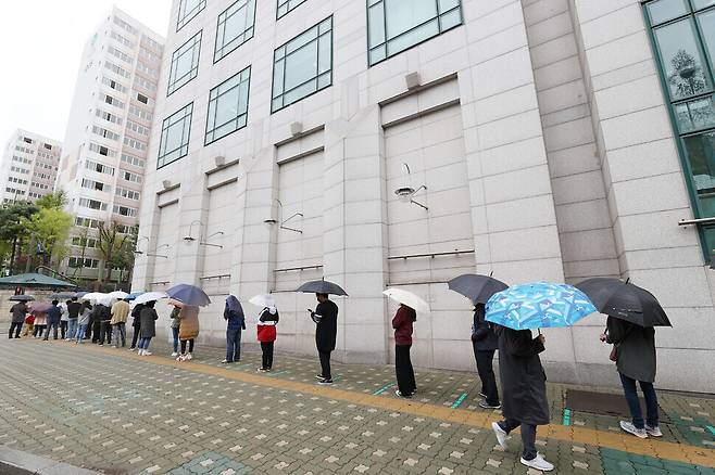 People wait in line for COVID-19 testing Monday at a temporary screening center set up at a public health center in Seoul. (Yonhap News)