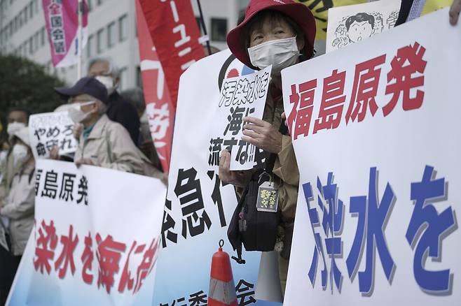 일본 정부의 후쿠시마 제1원전 오염수 바다 방류에 반대하는 일본 시민들이 13일 도쿄 총리관저 앞에서 연 집회에서 ‘오염수를 바다에 버리지 말라’ 등이 적힌 펼침막을 들고 시위하고 있다. 도쿄/AP 연합뉴스