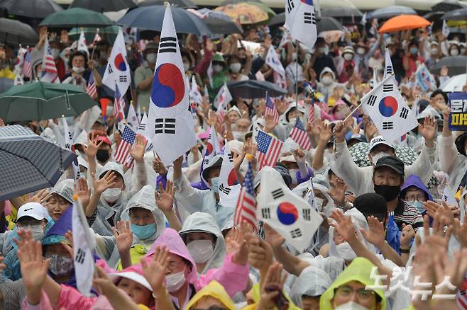 지난해 8월 15일 오후 서울 종로구 동화면세점 앞에서 열린 보수단체의 광복절 집회에서 참석자들이 태극기와 성조기를 흔들고 있다. 이한형 기자