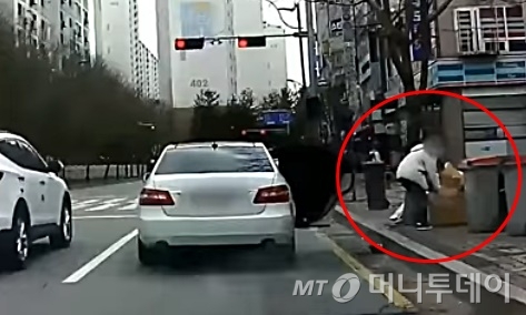 경기 파주시의 도로에서 한 운전자가 차에서 내린 뒤 차에 있던 쓰레기를 꺼내 버리고 있다./사진=유튜브 '한문철TV'