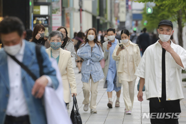 [도쿄=AP/뉴시스]13일 일본 도쿄에서 코로나19의 확산을 막기 위해 마스크를 쓴 사람들이 거리를 걷고 있다. 2021.04.13.