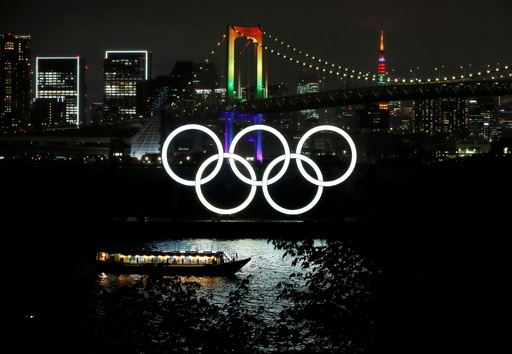 도쿄올림픽을 100일 앞둔 14일 일본 도쿄 오다이바 수변공원에 설치된 오륜기가 불을 밝히고 있다. 도쿄=로이터연합뉴스