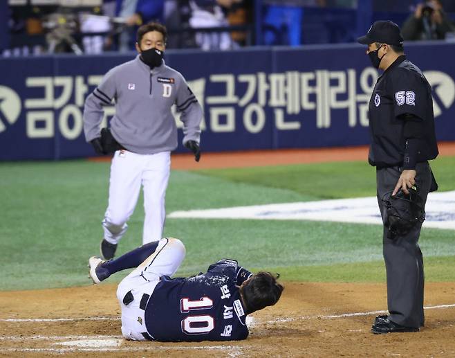 두산 박세혁이 16일 잠실 LG전에서 헤드샷을 맞고 쓰러져 고통스러워하고 있다. 연합뉴스