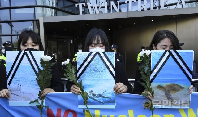 19일 서울 종로구 일본대사관 앞에서 YWCA 관계자들이 바다 장례식을 위해 조화와 영정을 든 채 묵념하고 있다.