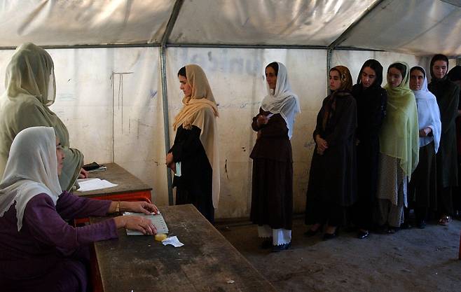 2004년 열린 첫 직선제 대선에서 아프간 여성들이 투표설명문을 받기 위해 줄을 서 있다. 파이자바드 | AP연합뉴스