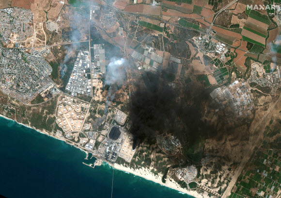 12일(현지시간) 팔레스타인 하마스의 공격으로 이스라엘 애슈켈론의 한 석유 탱크에서 불이 나 연기가 치솟고 있다. AP 연합뉴스