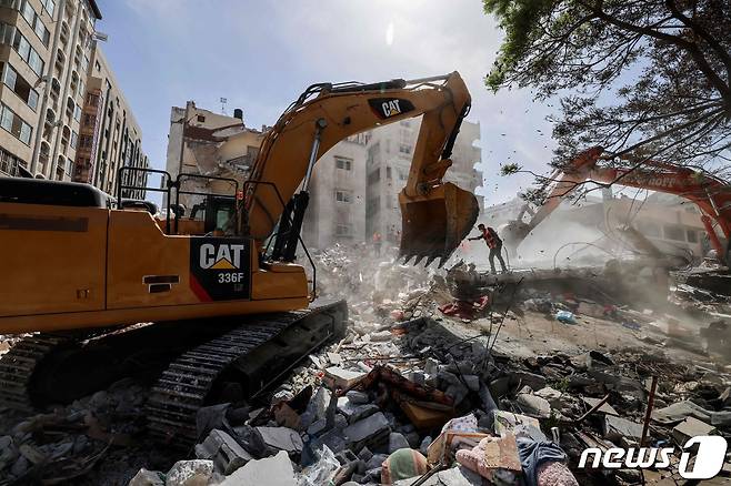 가자지구에서 공습으로 인해 무너진 건물을 포크레인이 처리하고 있다. © AFP=뉴스1