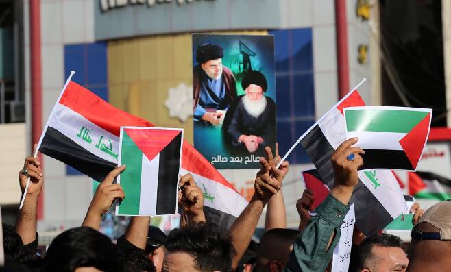 이라크 바그다드 시민들이 15일 알 타흐리르 광장에서 이라크와 팔레스타인 깃발을 들고 연대 집회를 열고 있다. EPA=연합뉴스
