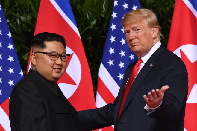 지난 2018년 6월 싱가포르에서 열린 1차 미북 정상회담에서 도널드 트럼프 미국 대통령(오른쪽)과 김정은 북한 국무위원장이 사진 촬영을 하고 있다. [AFP= 연합뉴스]