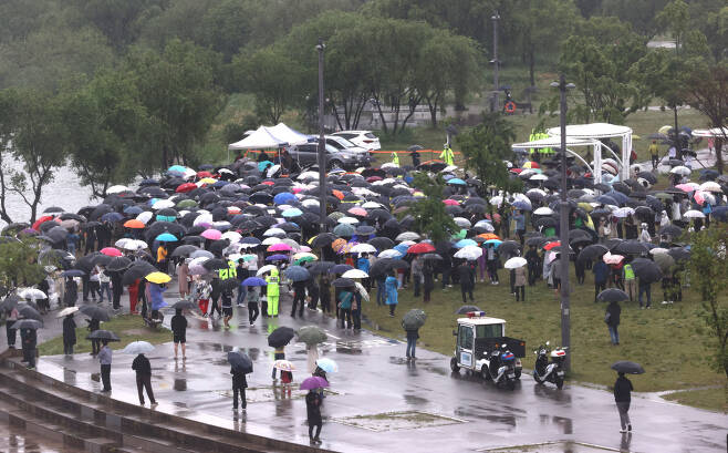 16일 오후 서울 반포한강공원 수상택시 승강장 인근에서 열린 '고 손정민 군을 위한 평화집회'에서 참가자들이 우산을 쓴 채 자리를 지키고 있다. [연합]