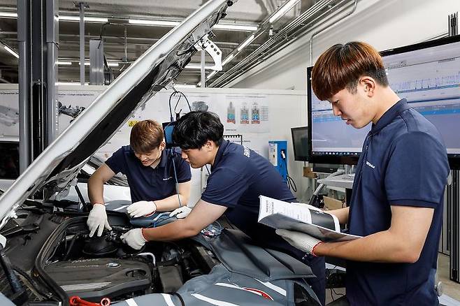출처: 아우스빌둥 프로그램으로 자동차 정비 실습을 배운 학생들이 BMW의 SUV인 ‘X3’의 보닛을 열고 내부를 살펴보고 있다.