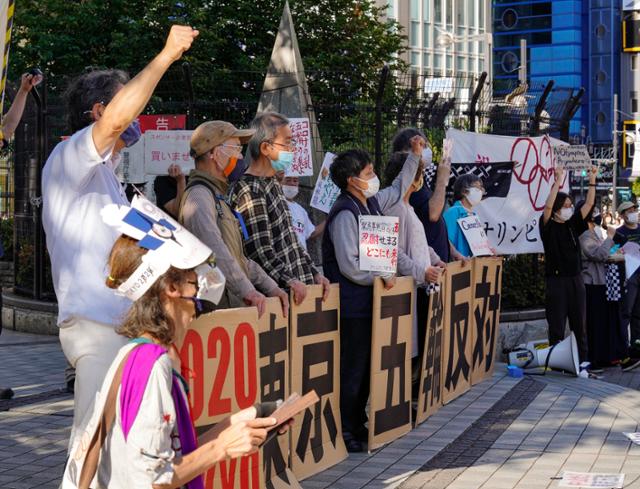 도쿄올림픽 개막 2개월을 앞둔 지난 23일 일본 수도 도쿄의 번화가인 신주쿠에서 시위대가 피켓 등을 들고 올림픽 개최 취소를 요구하는 시위를 벌이고 있다. 현지 언론의 최근 여론조사에 따르면 도쿄올림픽에 대해 43%가 '취소', 40%가 '재연기'를 주장했고, 올여름 개최를 지지한 응답자는 14%에 불과했다. 도쿄=EPA 연합뉴스