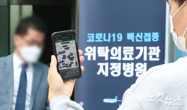 네이버와 카카오 앱을 통한 코로나19 잔여 백신 조회와 당일 접종 예약이 가능해진 지난 27일 오후 서울 양천구 홍익병원에서 한 시민이 네이버 앱을 이용해 예약을 시도하고 있다. 황진환 기자