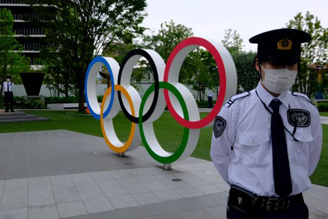 올림픽 조형물 앞에서 경비원이 경계를 서고 있는 모습. 도쿄=AFP 연합뉴스