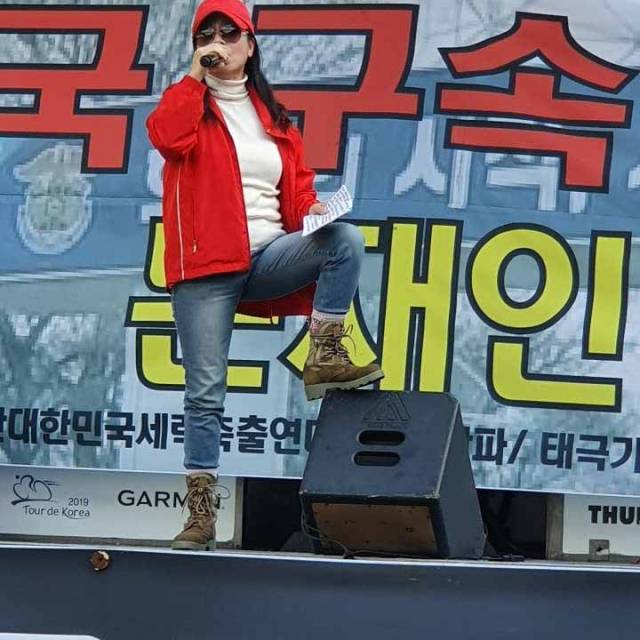 ▲ 태극기 집회에 참석한 임연희가 엠프에 왼쪽 다리를 올리고 "조국 구속" "문재인 퇴진"을 외치고 있다. ⓒ임연희 제공