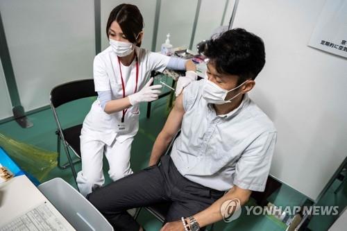 (도쿄 AFP=연합뉴스) 8일 일본 도쿄도(東京都)에서 의료 종사자가 소방대원에게 신종 코로나바이러스 감염증(코로나19) 백신을 주사하고 있다.