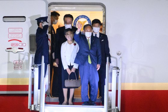스가 요시히데 일본 총리가 11일 G7 참석을 위해 영국 콘월 공항에 도착한 후 손을 흔들고 있다. [AFP=연합뉴스]