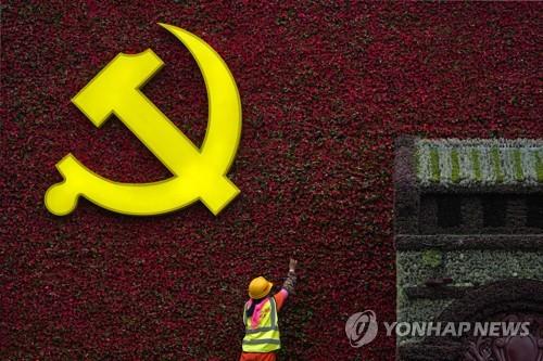 16일 베이징에서 한 작업자가 공산당 로고를 장식하고 있다. [AP=연합뉴스]