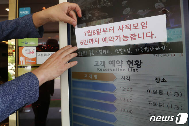 서울의 한 중식당에서 직원이 예약 현황판에 오는 8일부터 6인까지 예약이 가능하다는 안내문을 붙이고 있다. 2021.7.1/뉴스1 © News1 민경석 기자