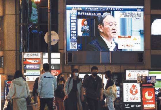 지난 7일 오후 스가 요시히데(菅義偉) 일본 총리가 신종 코로나바이러스 감염증(코로나19) 긴급사태에 관한 기자회견을 하는 모습이 일본 오사카(大阪)시 도심에 설치된 대형 스크린에 중계되고 있다.연합뉴스