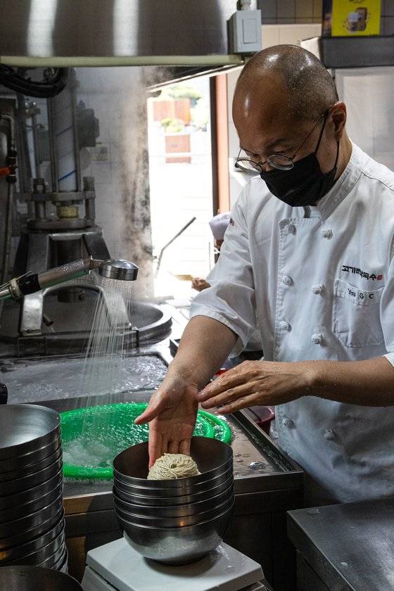 삶은 면발을 그릇에 담는 유수창 대표.