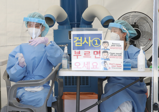 Medical workers get ready to carry out Covid-19 tests at a Covid-19 testing site in Nowon District, northern Seoul, on Sunday. [NEWS1]
