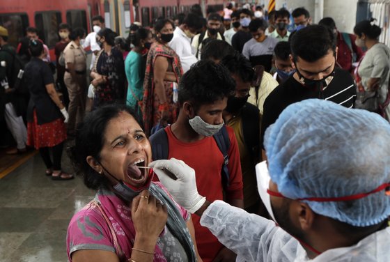 보건 관계자가 지난 22일(현지시간) 인도 뭄바이 기차역에서 여행객들을 대상으로 샘플을 채취하고 있다. AP=연합뉴스