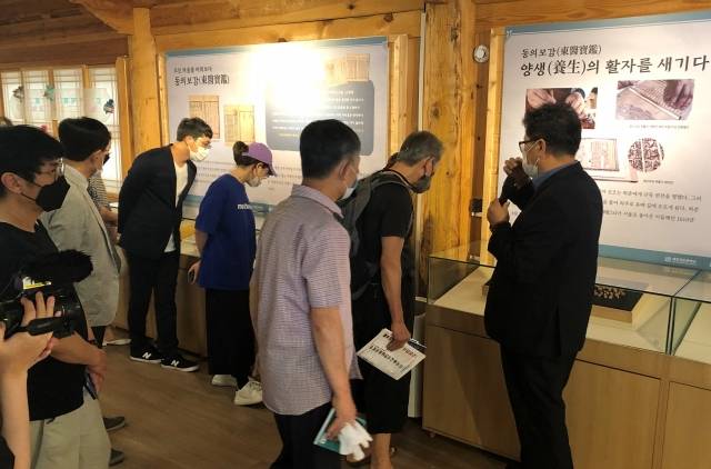 안준영 완판본문화관 관장(오른쪽)이 23일 개막된 '동의보감, 백세건강을 새기다' 전시회에서 목판 전시물들에 대해 설명하고 있디.