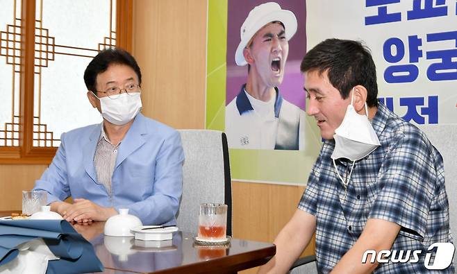 이철우 경북도지사가 25일 도쿄올림픽 양궁 혼성단체전에 출전하여 한국의 첫 금메달이자 최연소 금메달을 획득한 김제덕 선수의 부친인 김철규씨(50)를 예천군청에서 만나 축하하고 격려하고 있다.(사진 왼쪽부터 이철우 경북도지사, 김철규씨)© 뉴스1
