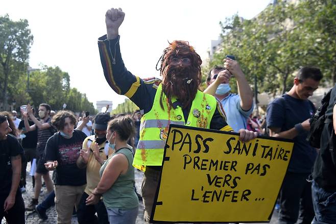 한 파리 시위대가 "보건 증명서는 지옥으로 가는 첫 걸음"이라고 쓴 플래카드를 들고 있다. AFP=연합뉴스