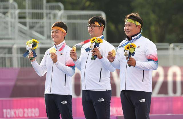 김제덕(왼쪽부터),김우진, 오진혁이 26일 도쿄 유메노시마 공원 양궁장에서 열린 2020 도쿄올림픽 남자양궁 단체전 메달 수여식에서 금메달을 들어 보이며 기뻐하고 있다. 도쿄=사진공동취재단