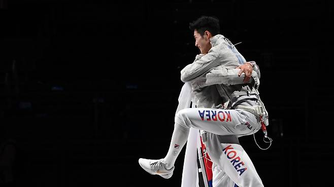 김준호가 28일 일본 지바 마쿠하리 메세 B홀에서 열린 2020 도쿄올림픽 펜싱 남자 사브르 단체 결승전 이탈리아와의 경기에서 승리한 뒤 오상욱에게 안기고 있다. 2021.07.28 지바=이태경 기자