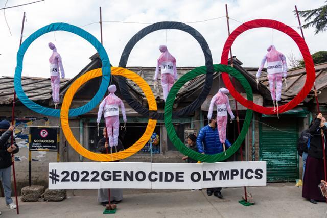 티베트 망명정부 관계자들이 지난 2월 인도 다람살라에서 '2022 베이징올림픽은 인종학살 올림픽'이라는 문구와 함께 오륜기에 사람 인형을 매달아 놓고 집회를 하고 있다. 다람살라=AP 연합뉴스