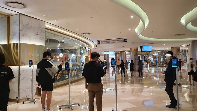 서울 송파구 롯데애비뉴엘 월드타워점 지하 출입구에서 방문객들이 QR코드를 인증하는 모습. /유한빛 기자