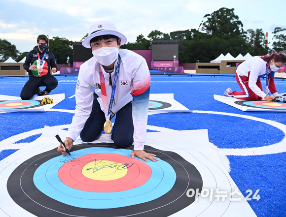 한국 양궁 안산이 30일 일본 도쿄 유메노시마공원 양궁장에서 열린 2020 도쿄올림픽 양궁 여자 개인전 결승에서 ROC(러시아올림픽위원회)의 옐레나 오시포바를 누르고 금메달을 차지했다. 안산이 과녁에 사인을 하고 있다.