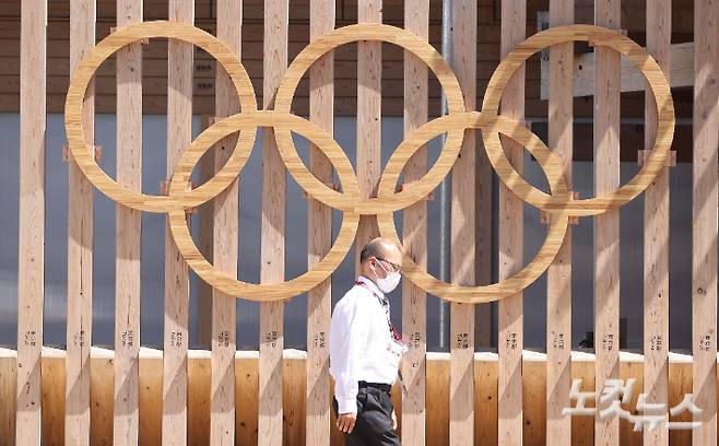 일본 도쿄 하루미 지역 올림픽선수촌 입구에서 관계자가 오륜기 조형물 앞을 지나고 있다. 올림픽사진공동취재단
