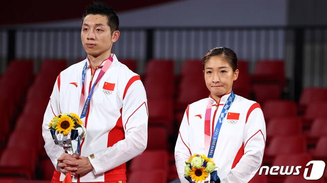 중국 탁구 혼합 복식조가 은메달을 따 시상대에 올랐지만 표정이 어둡다. © 로이터=뉴스1 © News1 박형기 기자