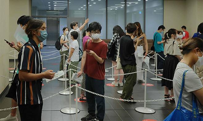지난 2일 하계올림픽이 열리고 있는 일본 수도 도쿄의 아오야마 대학교에 설치된 신종 코로나바이러스 감염증(코로나19) 백신 접종소에서 주민과 학생들이 백신을 맞기 위해 줄을 서서 차례를 기다리고 있다. 도쿄=AFP연합뉴스