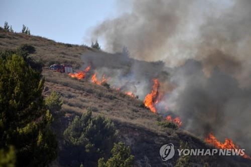 레바논에서 날아온 로켓포탄이 터지면서 화재가 발생한 이스라엘 키르낫 시모나. [로이터=연합뉴스]