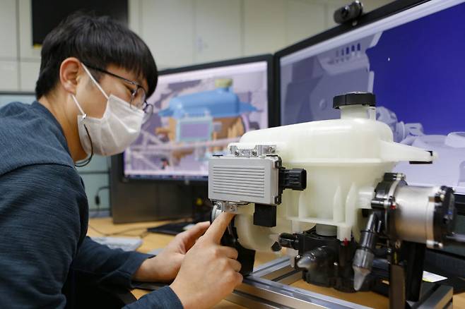 현대위아 연구원이 의왕연구소에서 전기차 전용 열관리시스템을 살펴보고 있다.