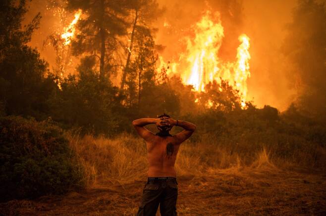 최근 그리스에서 산불이 확산중인 가운데 8일(현지시각) 한 주민이 불타는 숲을 바라보고 있다. AFP=연합뉴스
