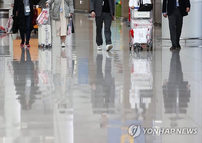 '면세야, 반가워' (영종도=연합뉴스) 신준희 기자 = 12일 영종도 인천국제공항에서 제주항공 무착륙 관광비행을 떠나는 이용객들이 구입한 면세품을 들고 탑승구로 들어가고 있다. 2020.12.12 hama@yna.co.kr