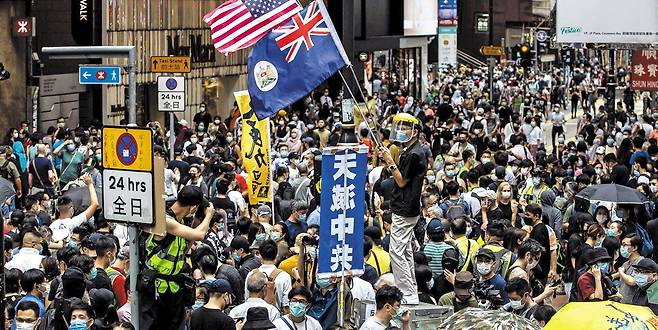 2020년 여름 홍콩 도심 코즈웨이베이에서 시민들이 중국의 홍콩 국가보안법 제정에 반대하는 시위를 벌이고 있다. 시위대가 영국 식민지 시절 홍콩 국기와 미국 성조기를 함께 들고 있다. '하늘이 중국 공산당을 멸할 것이다(天滅中共)'라고 적힌 팻말도 보인다.