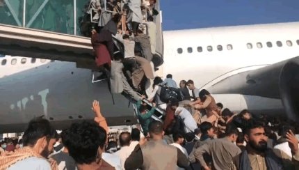 아프가니스탄 수도 카불의 하미드 카르자이 공항에서 16일 이 나라에서 탈출하려는 사람들이 문 열린 비행기에 탑승하려고 필사적으로 탑승교에 오르고 있다. 사진 트위터 캡처
