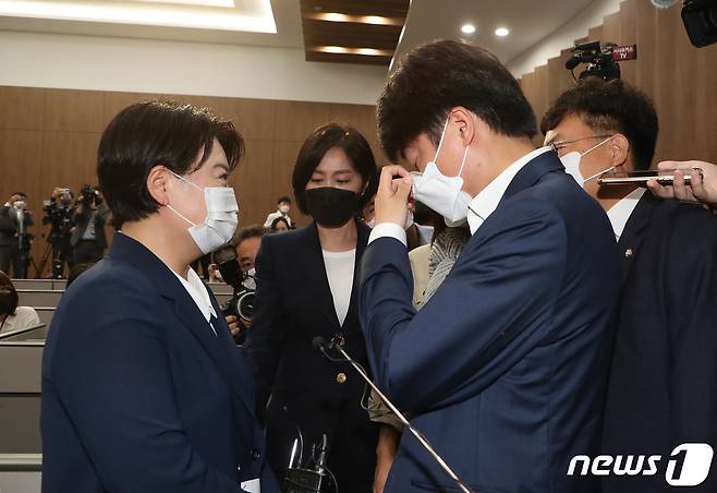 25일 국회 소통관에서 국민권익위원회의 부동산 전수조사에서 농지법 위반 의혹이 제기된 의혹으로 윤희숙 국민의힘 의원이 의원직 사퇴를 선언한 가운데 이준석 대표가 기자회견장으로 찾아와 윤 의원을 만류하다 눈물을 훔지고 있다. 2021.8.25/뉴스1 © News1 이동해 기자