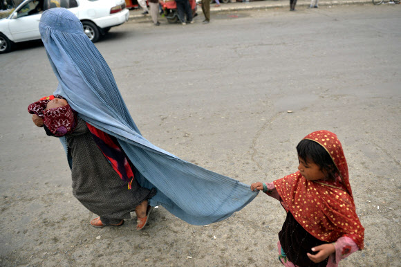 아프간 카불의 부르카 입은 여성 - 미군이 철수한 다음날인 31일(현지시간) 아프간 수도 카불의 한 거리에서 부르카를 입은 여성이 아이와 함께 길을 가고 있다. 2021.8.31 AFP 연합뉴스