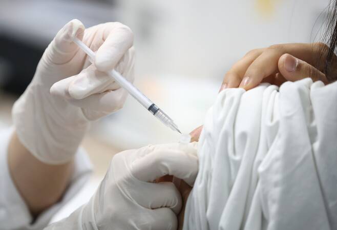 7일 오후 서울 마포구민체육센터에 마련된 코로나19 예방접종센터에서 의료진이 화이자 백신을 접종하고 있다/연합뉴스