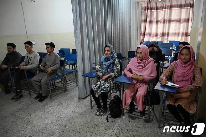 지난 7일(현지시간) 아프가니스탄 카불의 대학에서 남녀 구분을 위해 강의실 한가운데 커튼을 치고 학생들이 수업을 받고 있다. © AFP=뉴스1 © News1 우동명 기자