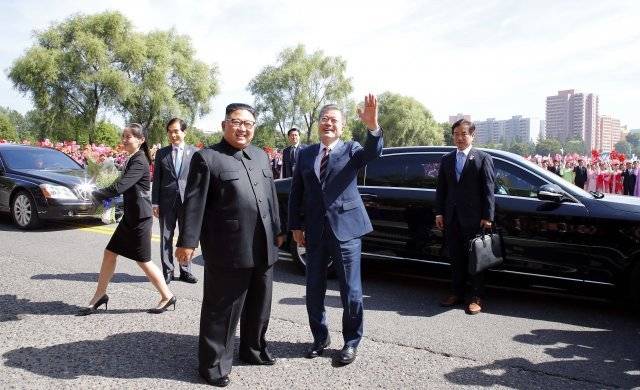 문재인 대통령과 김정은 국무위원장이 무개차를 함께 타기 전 평양 시민들을 향해 손을 흔드는 모습. 왼쪽에 자리를 피하는 김여정 부부장의 모습이 보인다. 평양사진공동취재단
